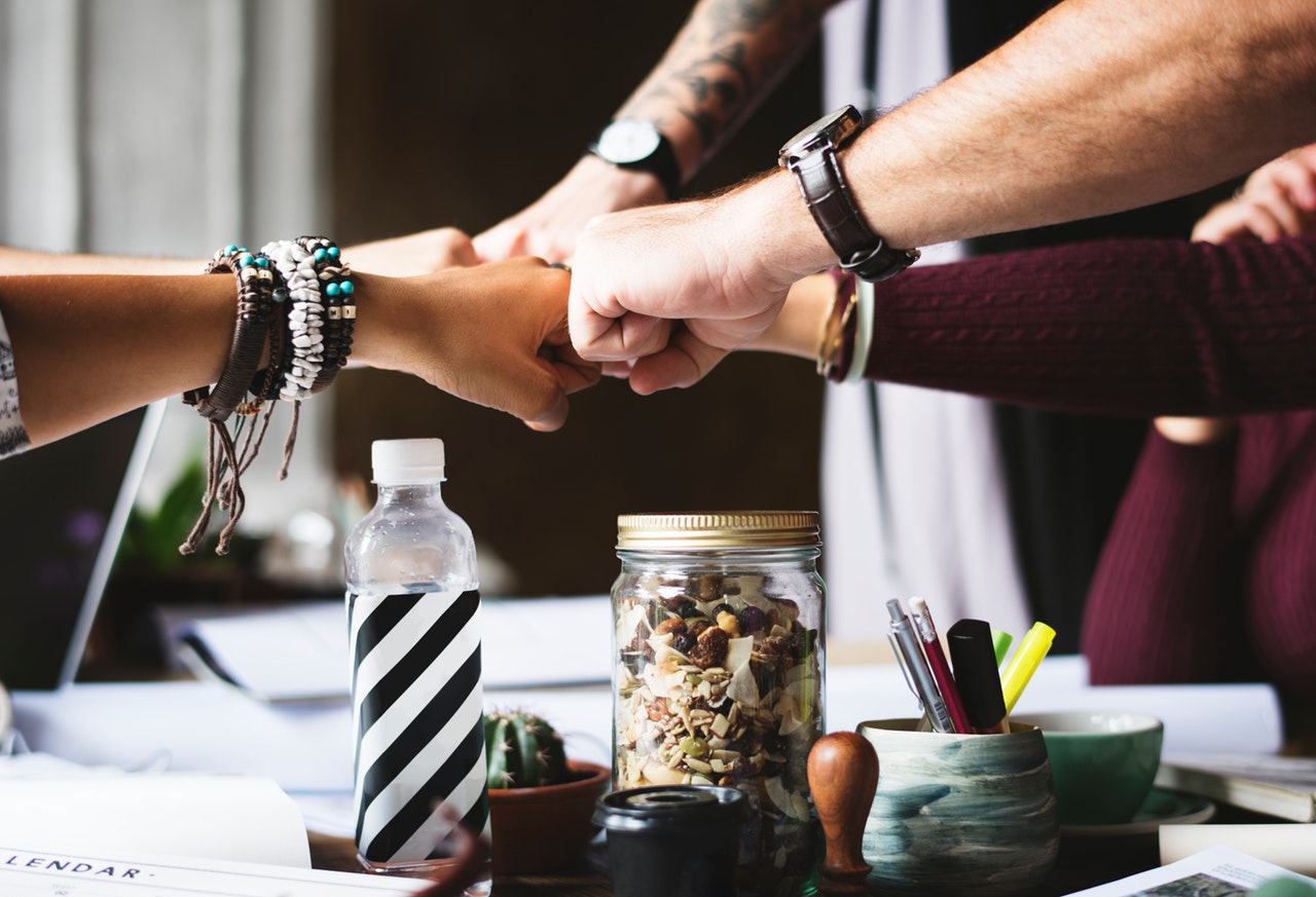 Group fistbump over work table.