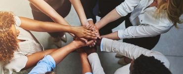 Group of people in a circle with hands together