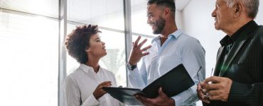 Three people in an office talking about Talent Attraction