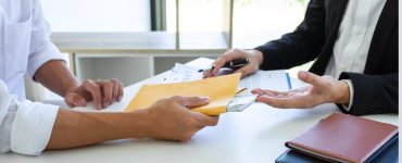 Person signing a contract and being given cash